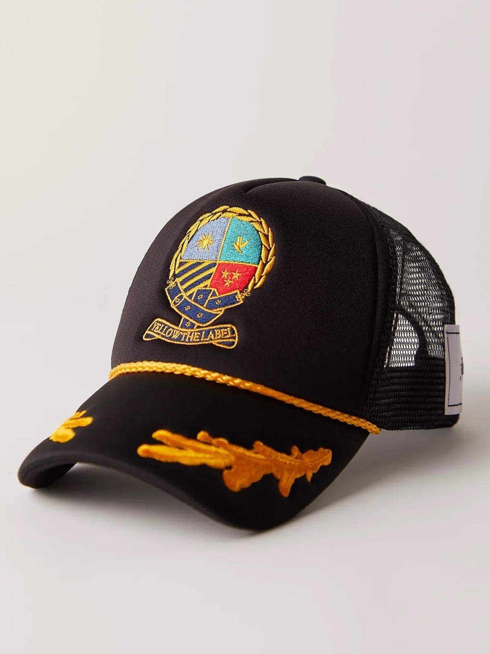 YLLW HERALD CREST TRUCKER HAT yellow the label